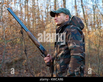 Hunter in camo suit with double barrel shotgun Stock Photo