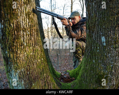 Hunter in camo suit with double barrel shotgun Stock Photo