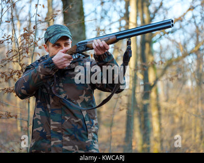 Hunter in camo suit with double barrel shotgun Stock Photo