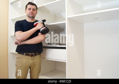Service man near new wardrobe at the time of installation. Stock Photo