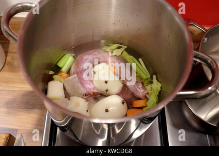 Turkey stock made from giblets and vegetables including onion carrot and celery simmering on gas hob in pot Stock Photo