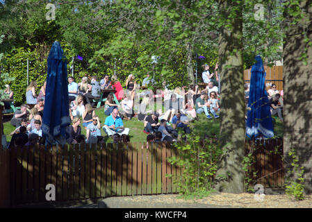 beer garden  crowd sitting on grass brel bars and restaurants eating out food and drink Glasgow in the summer sun Ashton Lane, Glasgow, United Kingdom Stock Photo