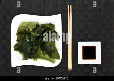 Japanese wakame seaweed health food with low sodium soy sauce on porcelain dishes with chopsticks. Has many benefits for a healthy life. Stock Photo