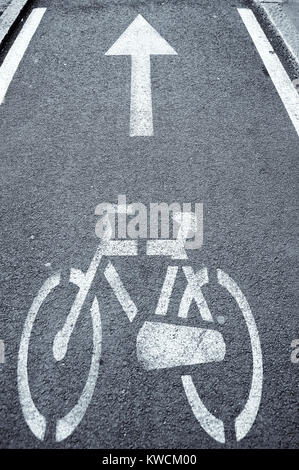 Bike path - bicycle and arrow painted on asphalt - road markings Stock Photo
