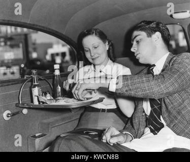 Drive-in restaurant in Hollywood, Los Angeles. June 29, 1938. California couple enjoying lunch in the back seat of their car. Their food is on a tray fastened inside of the window. - (BSLOC 2014 17 113) Stock Photo