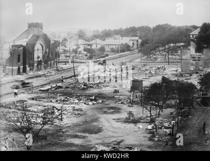 Part of district burned in 1917 Tulsa race riots, including the ruins of Mt. Zion Baptist Church. Three people walk in through the devastation  (BSLOC 2017 20 80) Stock Photo