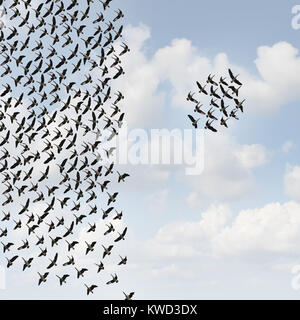 Independent group thinkers concept and new team leadership concept or teamwork individuality as a crowd of flying birds with one small grouping. Stock Photo