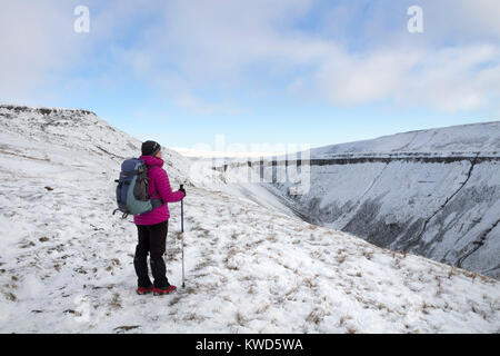 Walker Viewing a Snowy High Cup Nick from the Pennine Way in Winter, Cumbria, UK Stock Photo