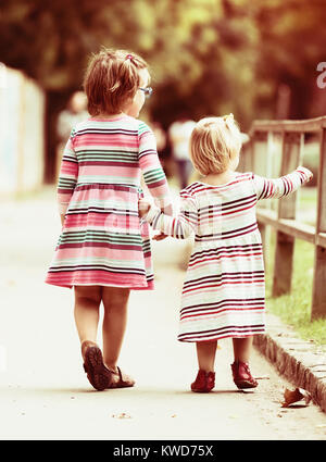 Rear view of two little girls at street Stock Photo