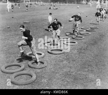 West Point's football squad high stepping through a maze of tires during their first practice. 1920s. (BSLOC 2015 17 127) Stock Photo