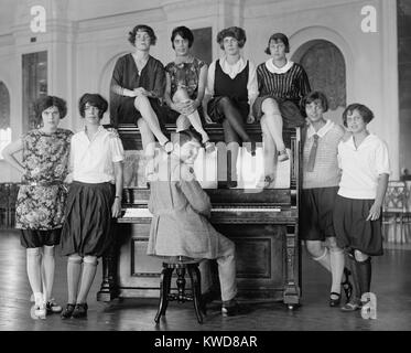 Group of young women described as 'Debutantes' wearing bloomers around a man at a piano. Oct 8, 1923. Washington, D.C. vicinity, (BSLOC 2015 17 209) Stock Photo