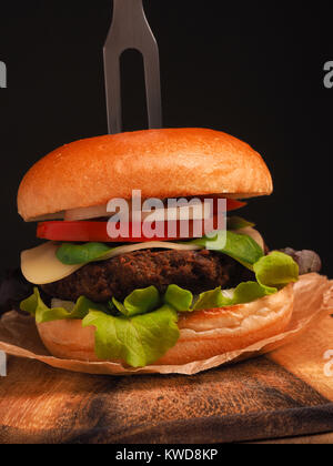 Tasty homemade burger with organic beef on a rustic wooden kitchen table, healthy food concept Stock Photo