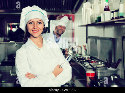 Smiling  professional chefs working in restaurant kitchen Stock Photo
