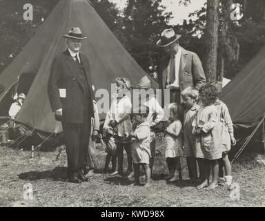 Herbert Hoover with girls and boys at a tent camp during the Great Mississippi River Flood in 1927. The worst effected states were Arkansas, Mississippi, and Louisiana. Hoover, then Sec. of Commerce, was named by President Coolidge to coordinate flood relief with the American Red Cross. (BSLOC 2015 16 67) Stock Photo