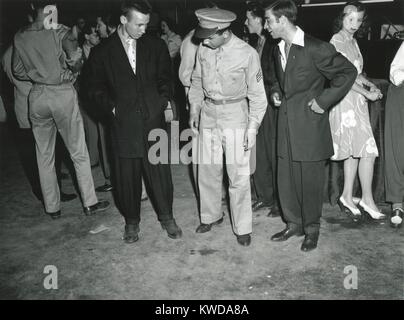 Soldier inspects Zoot Suiters at an intermission of Woody Herman's Orchestra engagement. At the Uline Arena, Washington, D.C., June 1942. Oversized Zoot Suits flaunted World War 2 fabric rationing, and later because as source of street fighting between Zo (BSLOC 2016 7 9) Stock Photo