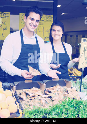 russian salespeople with farm mushrooms in market, prices are on Spanish Stock Photo