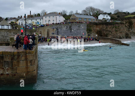 Boxing Day swim at Charlestown harbour, near St Austell, Cornwall. Locals swim for charity. The harbour is a UNESCO world heritage site. Stock Photo