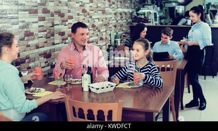 Cheerful family with teenagers having lunch in cozy cafe Stock Photo