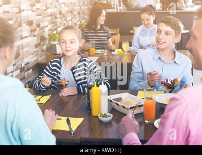 Glad family having lunch in cozy cafe Stock Photo