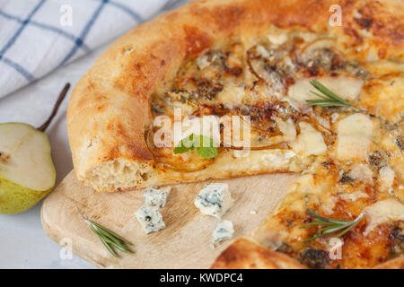 Hot delicous pizza with pear and blue cheese on wooden board. Vegetarian healthy food concept, traditional Italian food. Stock Photo