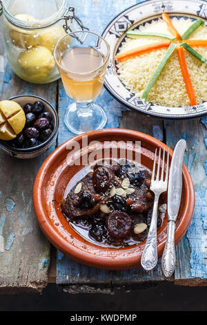 Traditional moroccan dishes: beef tajine, couscous, olives and salted lemons. Rustic style Stock Photo