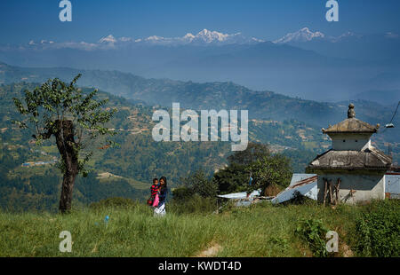 Newari girl carrying baby in front of Himalaya Range, Dulikhel, Katmandu Valley, Nepal Stock Photo