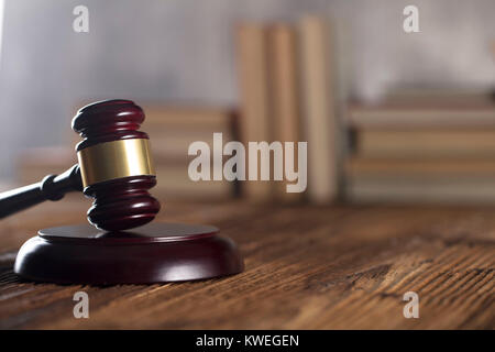 Gavel of judge on rustic wooden table. Bookshelf background. Stock Photo