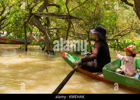 Asian Cambodian woman and young daughter paddling a canoe, exploring floating forest flooded forest in Kampong Phluk, Tonle Sap Lake Cambodia Stock Photo