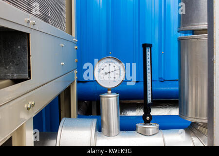 The pressure Gage and thermometer in water cold pipe on air condition system Stock Photo