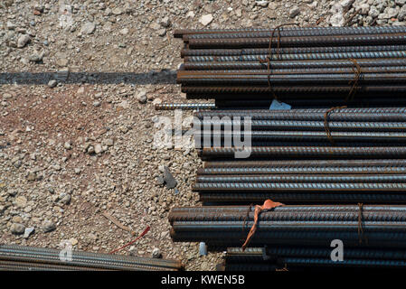 Cut steel bars and rods sitting on the ground of a construction site waiting to be mixed with concrete in building foundations Stock Photo