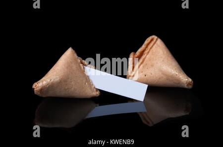 Cracked fortune cookie isolated on black background Stock Photo