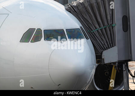 A commercial aircraft parked and connected to an air bridge at an airport in Australia Stock Photo