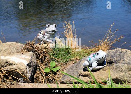 Garden accessory frogs sitting on rocks. Stock Photo