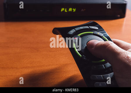 Male pointing the TV remote control to the TV box Stock Photo