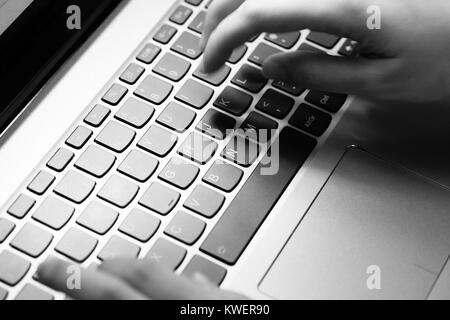 Young man uses laptop to electronically pay bills with his credit card Stock Photo
