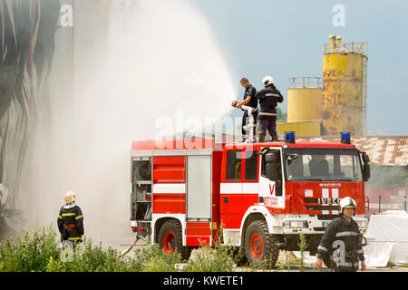 Sofia, Bulgaria - July 15, 2017: Firefighters extinguish fire disaster in a warehouse. Fire fighting in an industrial area. Stock Photo