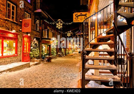 Christmas decorations and fresh snow in Quebec City's Petit Champlain area at night - in Rue Petit Champlain Stock Photo