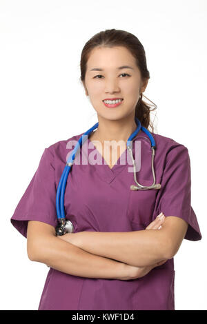 Beautiful Asian American doctor or nurse wearing blue scrubs and posing with stethoscope isolated on white background Stock Photo