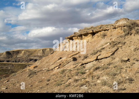 Eroded slopes in Alberta badlands, with sandstone layer above bentonite clay Stock Photo