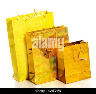 Three yellow paper bags for gifts isolated on white Stock Photo