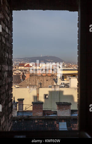 View of Budapest rooftops from a brick window in the centre of the city. January 2018, morning light Stock Photo