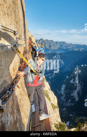 Mount Hua, Shaanxi Province, China - October 6, 2017: Tourists on the Plank Walk in the Sky, worlds most dangerous hike. Stock Photo