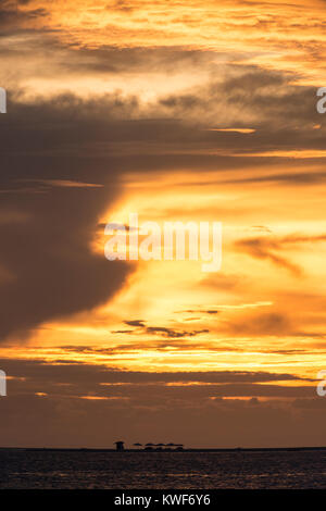 Fisherman reeling in his nets during sunset Stock Photo