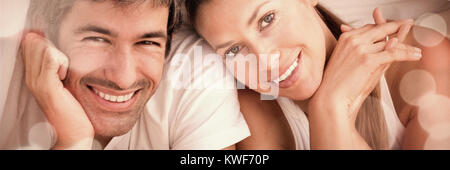 Enamoured couple having fun lying on bed Stock Photo