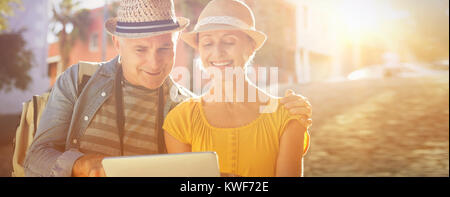 Happy tourist couple using tablet pc in the city Stock Photo