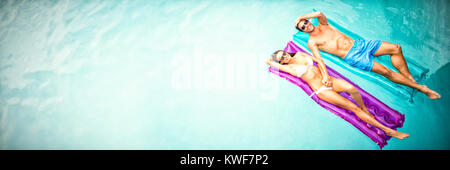 Couple relaxing in swimming pool Stock Photo