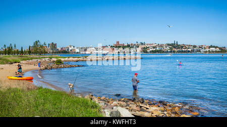 Australia, New South Wales, Hunter Region, fising on the banks of the Hunter River at Stockton with view of Newcastle across the Hunter River Stock Photo