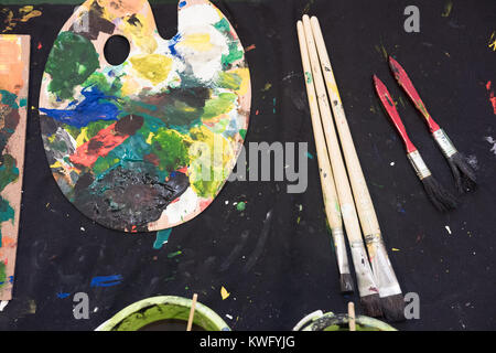 Used paint brushes with watercolor set Old paint cans and colors colorful and paint brush. Stock Photo