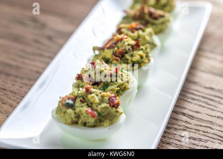 Bacon guacamole deviled eggs Stock Photo