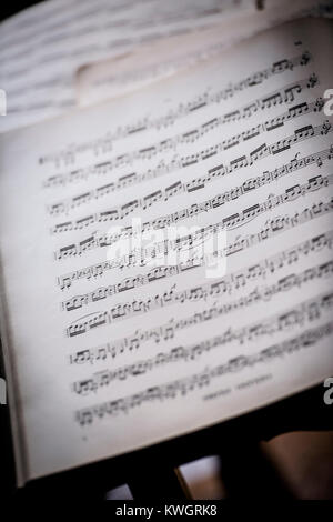 A page of sheet music for violin lying on a table. Stock Photo